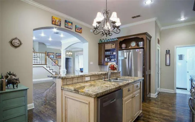 a hall with kitchen island granite countertop furniture and a chandelier
