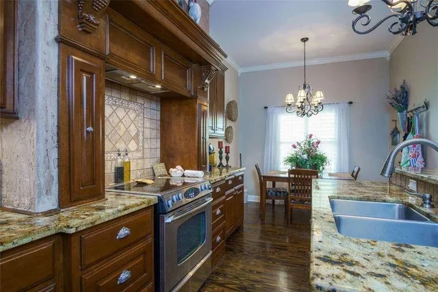 a kitchen with stainless steel appliances granite countertop a stove and a wooden floors