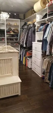 a view of walk in closet with clothes and shoes