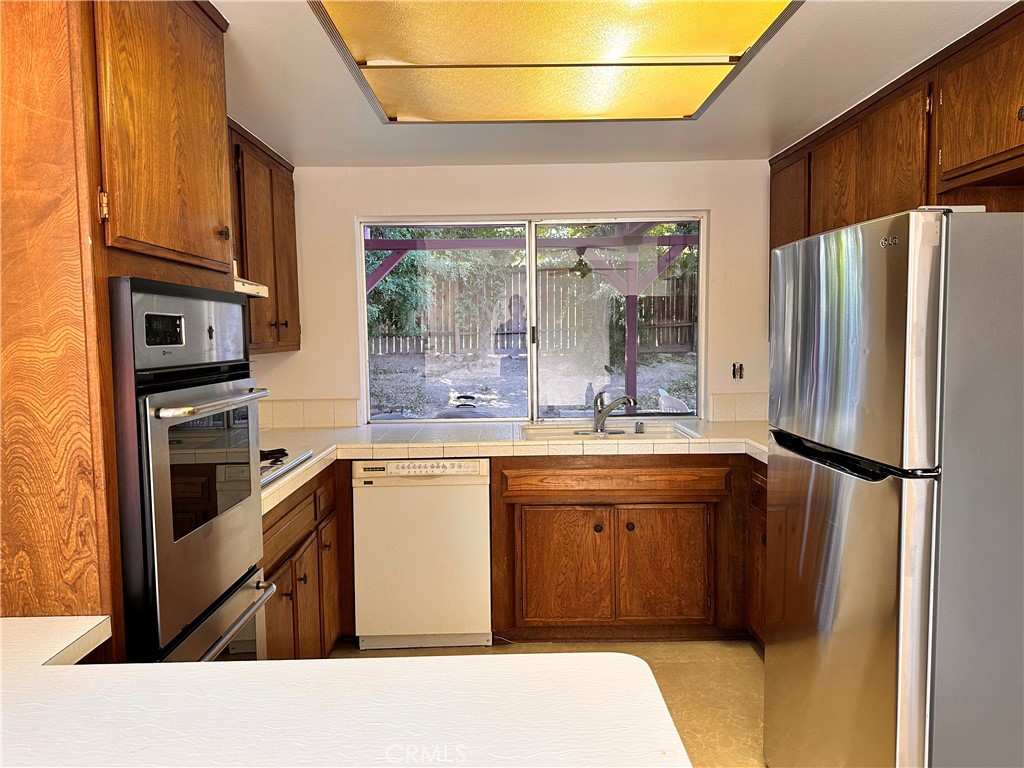 23712 Highlander Road West Hills, CA 91307 - Photo 9 of 21 a kitchen with stainless steel appliances a refrigerator sink and cabinets