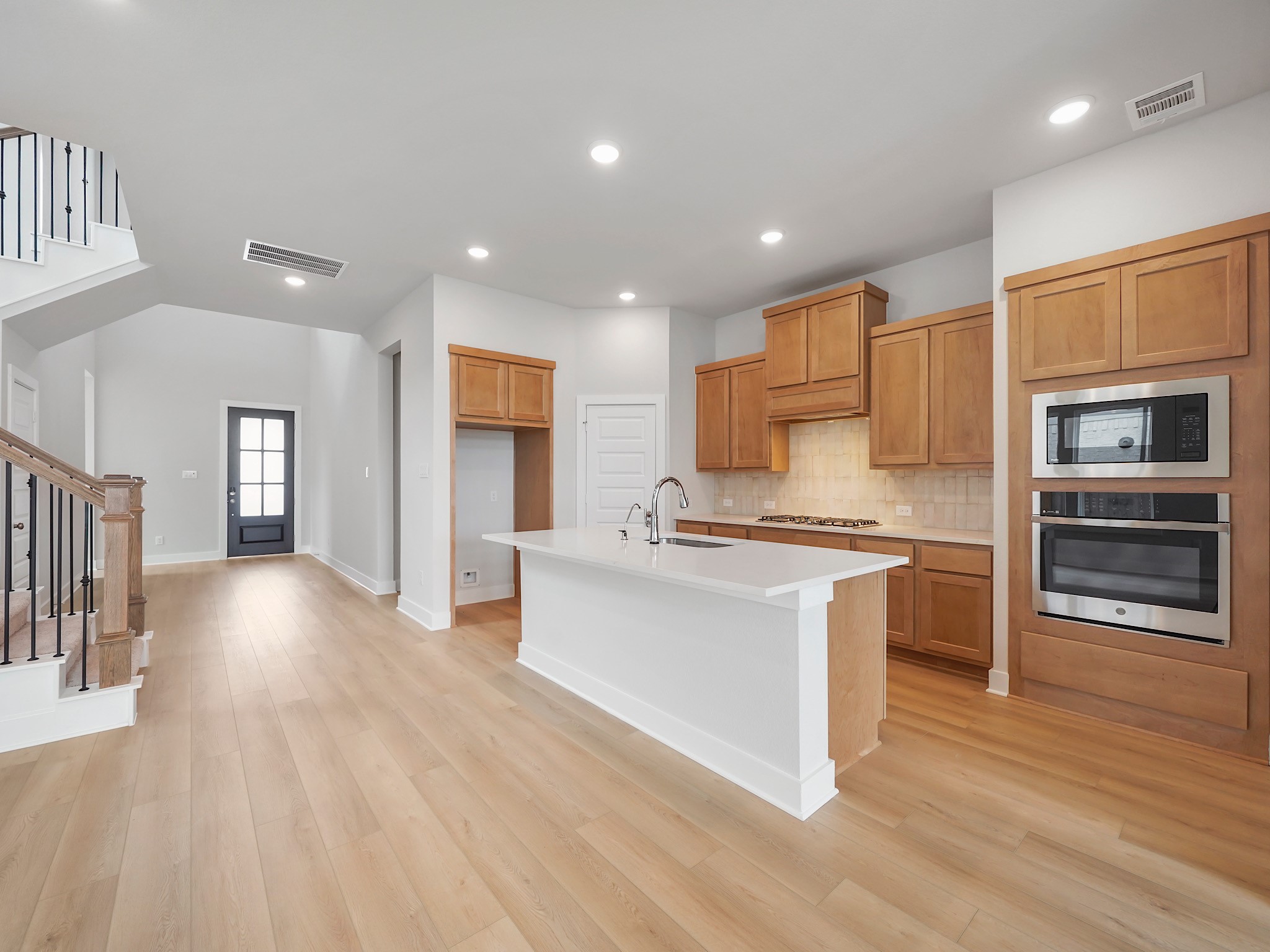 6010 Rolling Strm Court Fulshear, TX 77441 - Photo 4 of 23 Prepare to be captivated by this home's stunning gourmet island kitchen! Imagine yourself creating culinary masterpieces in this spacious haven, featuring warm, soothing-toned cabinets that radiate comfort and elegance.