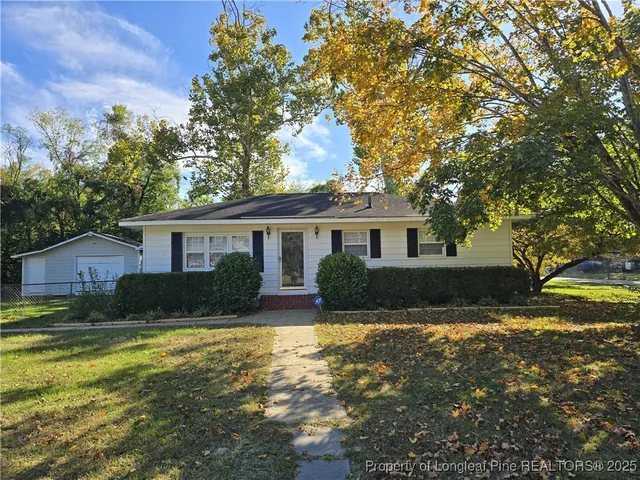 a view of a yard in front of a house with large tree