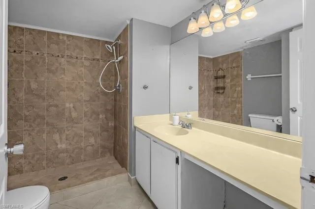 a bathroom with a granite countertop sink toilet shower and a mirror