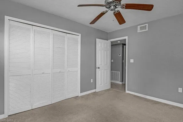 a view of an empty room and chandelier fan
