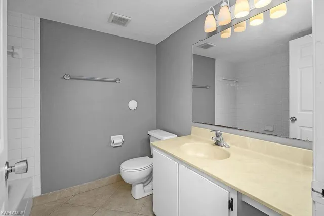 a bathroom with a granite countertop sink a toilet and a mirror