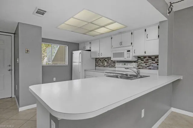 a kitchen with stainless steel appliances a refrigerator a sink a stove a microwave and island