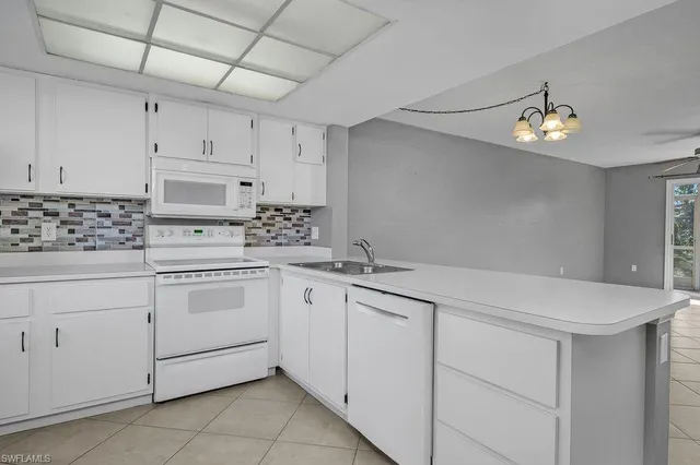 a kitchen with white cabinets appliances and a sink