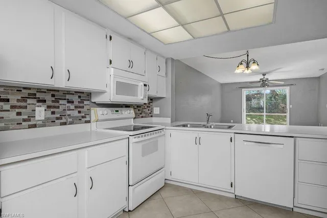 a kitchen with cabinets appliances a sink and a window