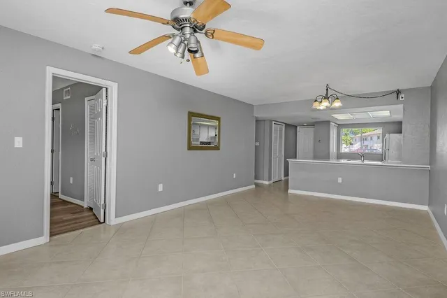 an empty room with windows and ceiling fan