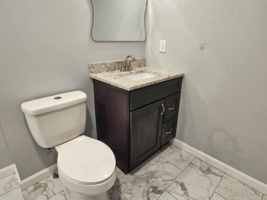 5 William Street Acushnet, MA 02743 - Photo 14 of 20 a bathroom with a toilet a sink and mirror