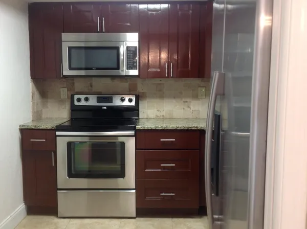 a kitchen with stainless steel appliances granite countertop a refrigerator and a sink