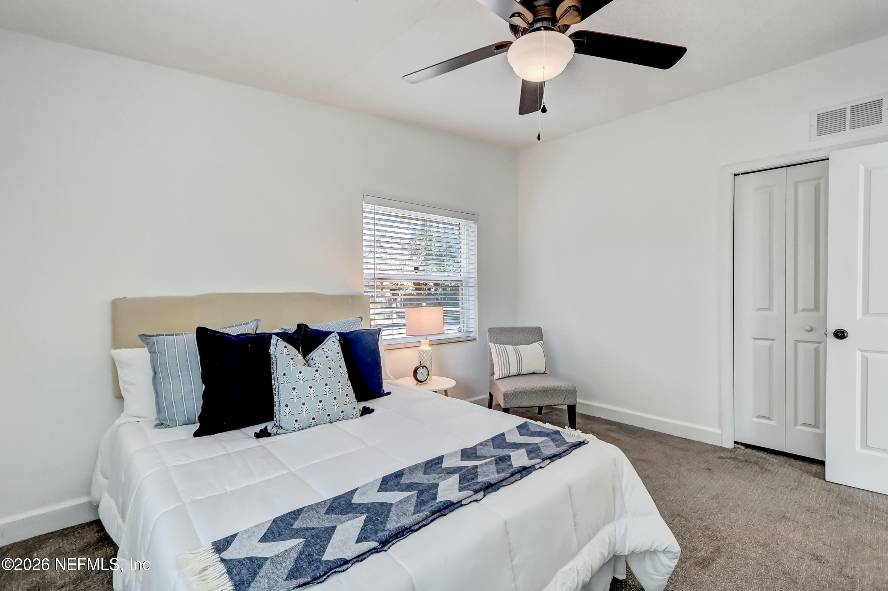 2477 Community Road Jacksonville, FL 32207 - Photo 18 of 33 a bedroom with a bed and a ceiling fan