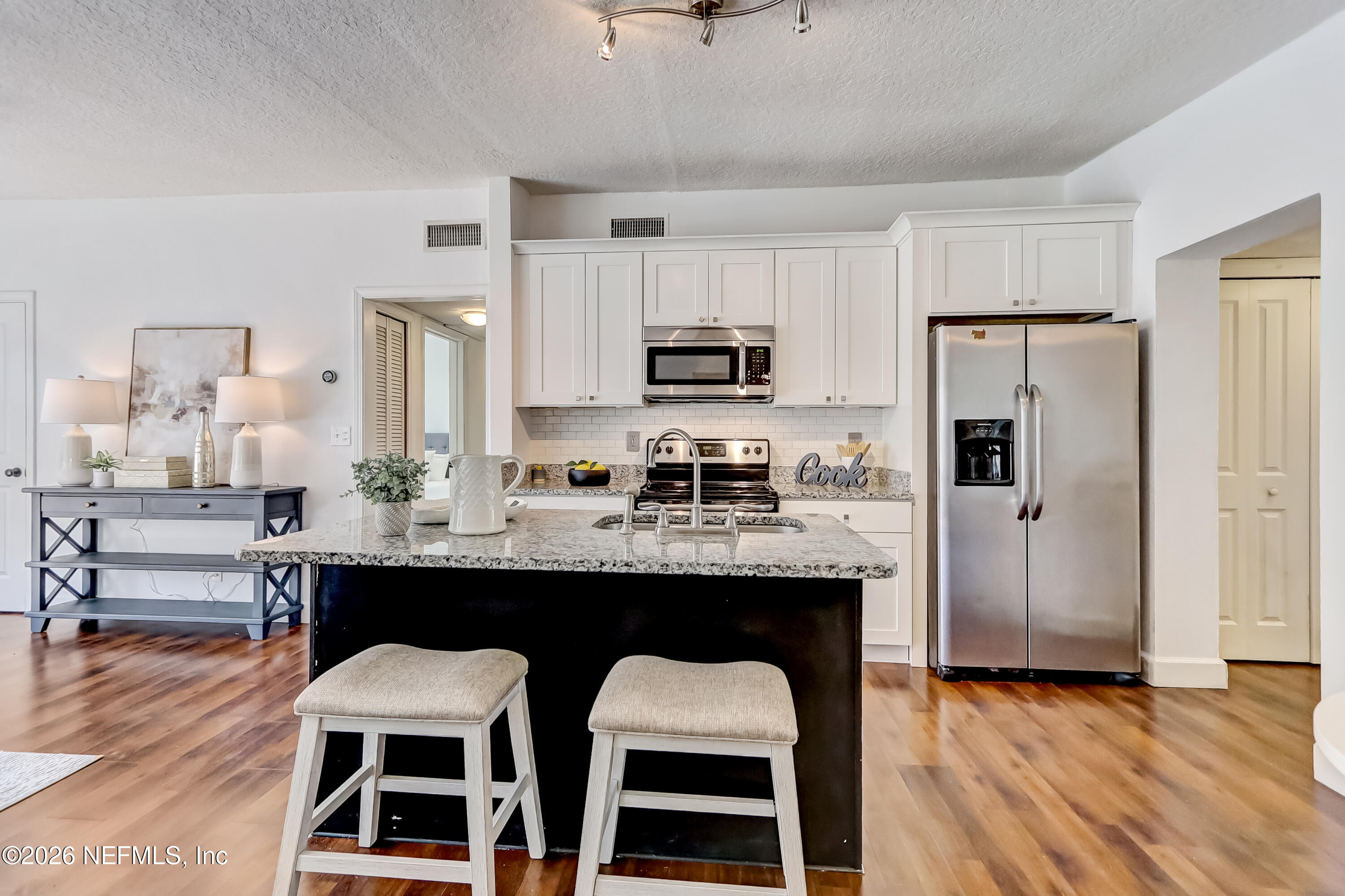 2477 Community Road Jacksonville, FL 32207 - Photo 6 of 33 a kitchen with kitchen island granite countertop a sink cabinets and refrigerator