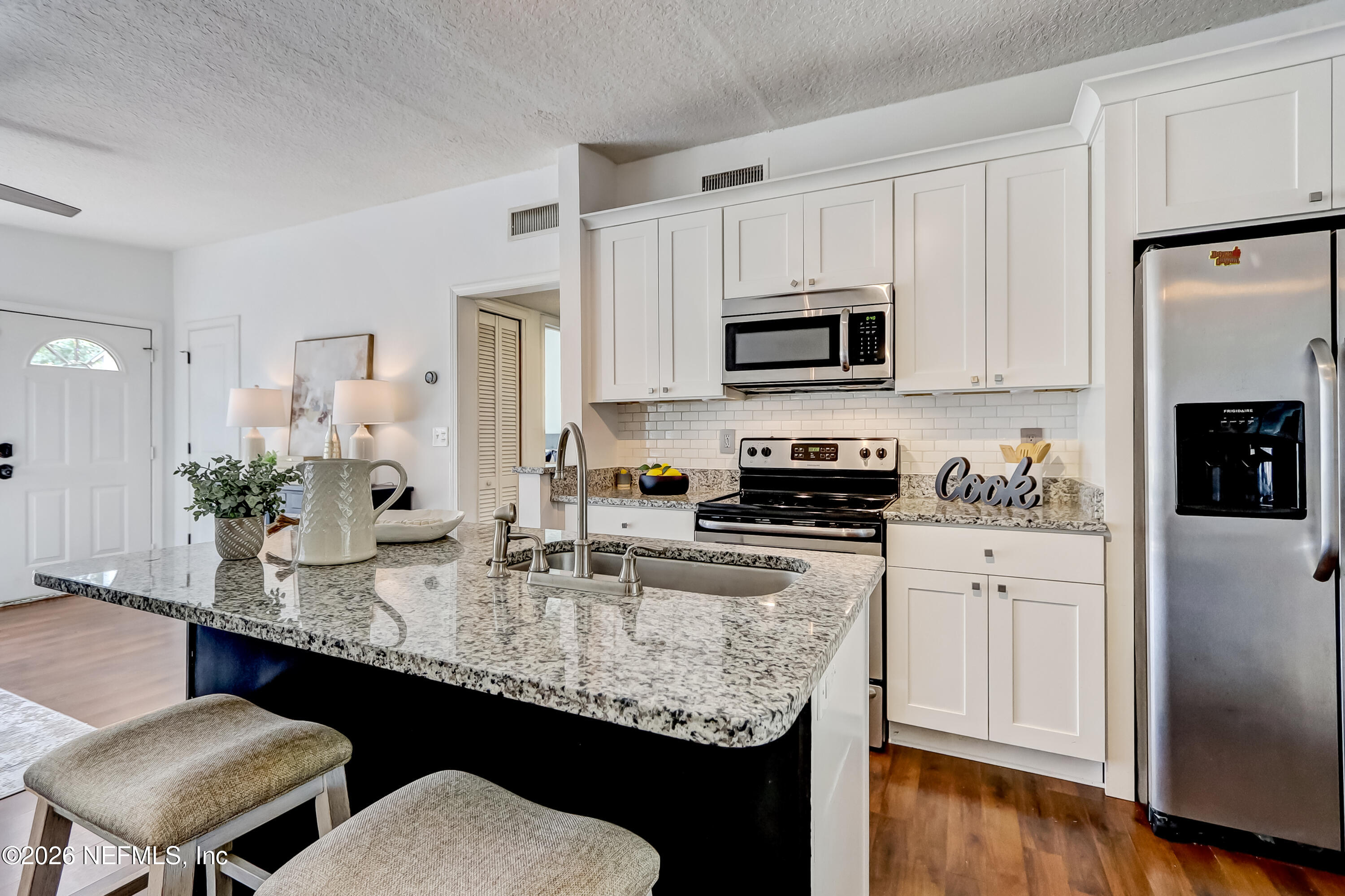 2477 Community Road Jacksonville, FL 32207 - Photo 8 of 33 a kitchen with stainless steel appliances granite countertop a sink stove microwave and refrigerator