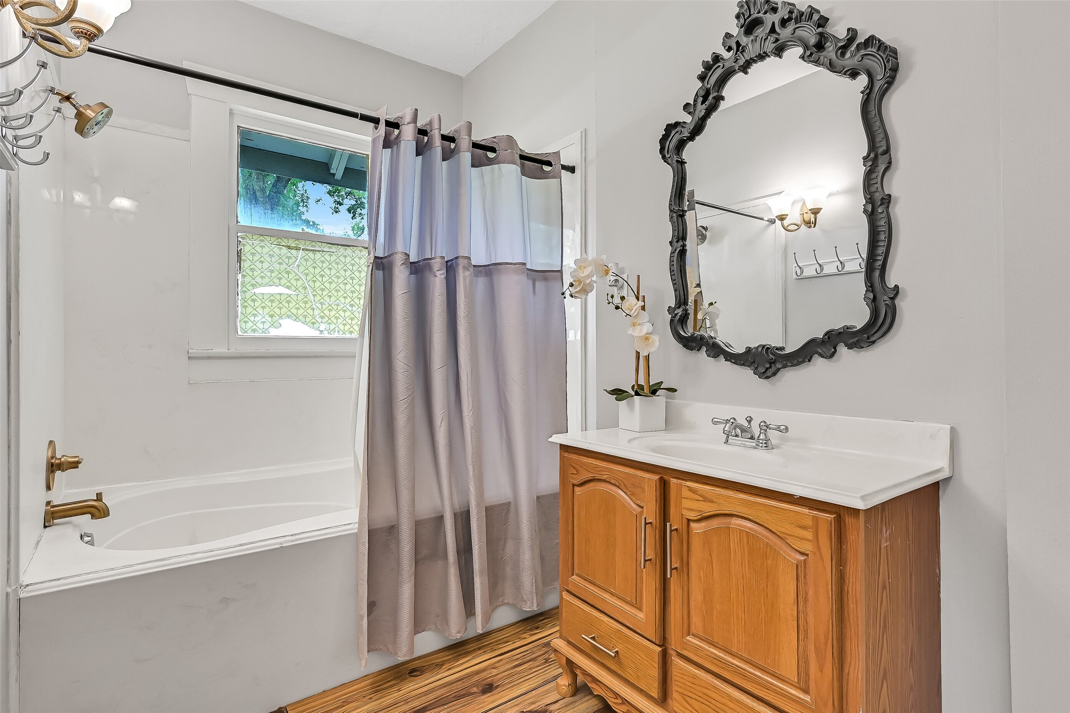 16724 Harkey Road Pearland, TX 77584 - Photo 21 of 34 The bathroom offers an oversized tub, filigree mirror with sconce lighting, and wall of custom wood built-ins (not pictured) that serve as storage and linen closet. Plenty of room to re-imagine this space!