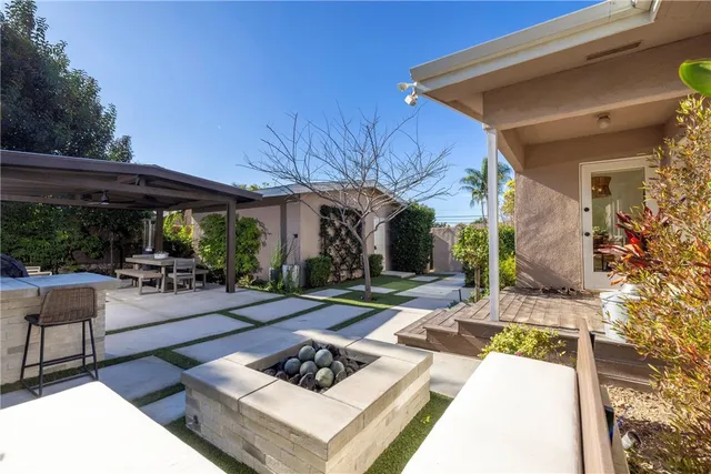 a patio with a table and chairs and potted plants