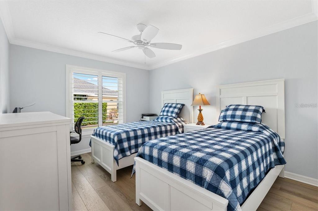 3394 Ridgewood Path The Villages, FL 32163 - Photo 19 of 30 a bedroom with two beds and a chandelier