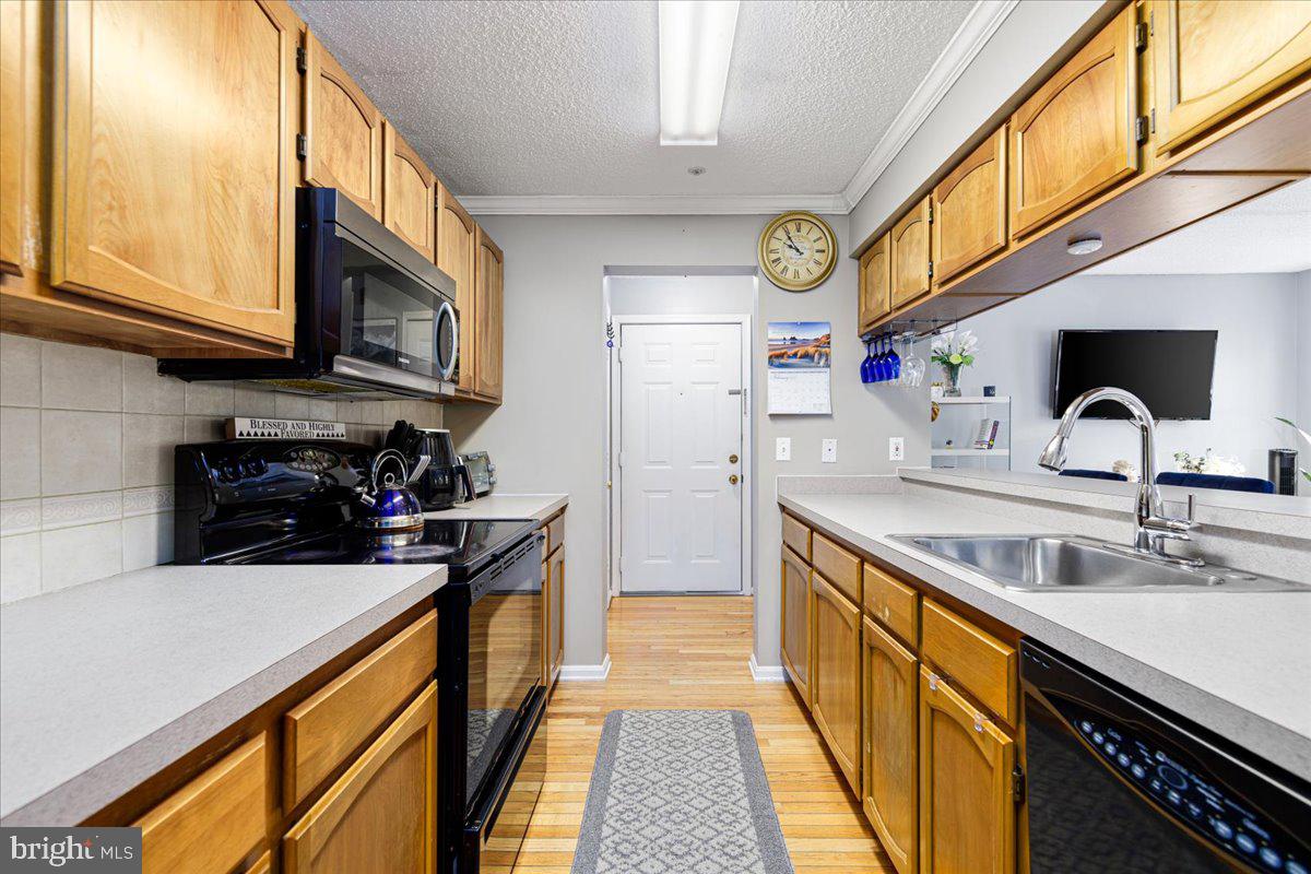 14018 Valleyfield Drive, Unit 8 Silver Spring, MD 20906 - Photo 11 of 20 a kitchen with stainless steel appliances a sink a stove and cabinets