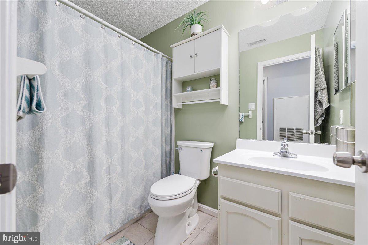 14018 Valleyfield Drive, Unit 8 Silver Spring, MD 20906 - Photo 14 of 20 a bathroom with a sink a toilet and shower curtain