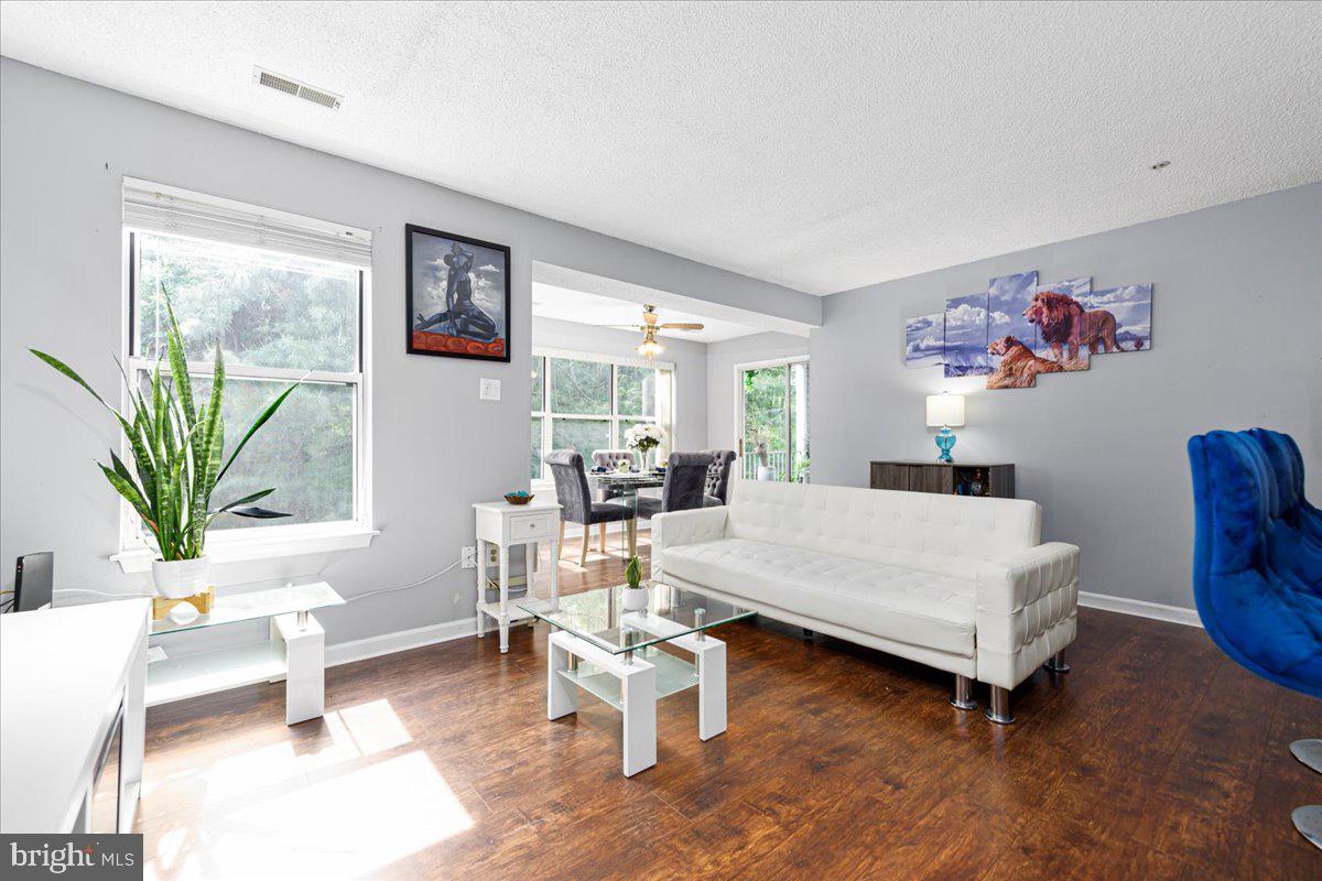 14018 Valleyfield Drive, Unit 8 Silver Spring, MD 20906 - Photo 4 of 20 a living room with furniture a wooden floor and a large window
