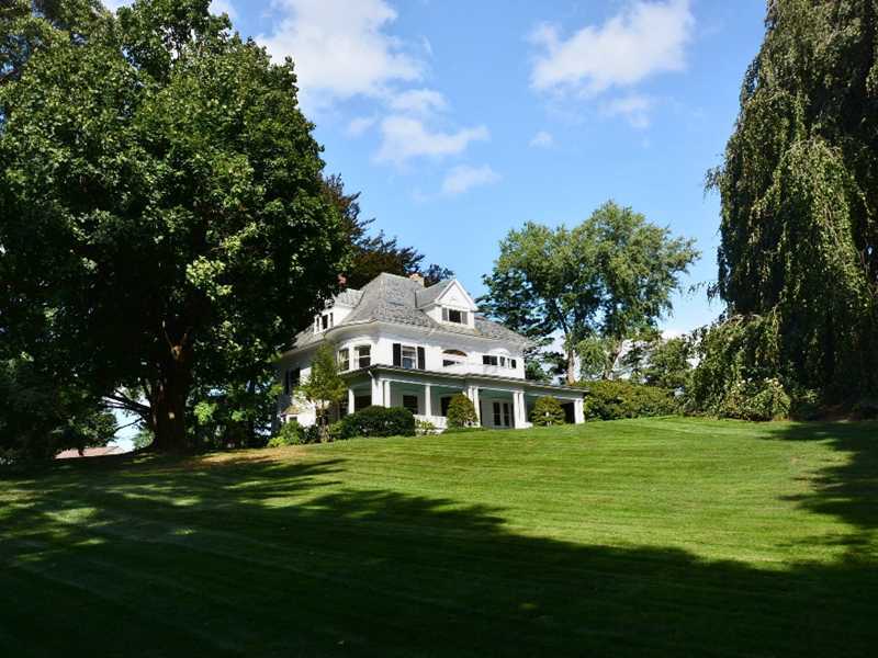 66 Pear Tree Point Road Darien, CT 06820 - Photo 3 of 25 a view of a white house with a big yard and potted plants and large trees