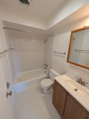 a bathroom with a granite countertop toilet sink and mirror