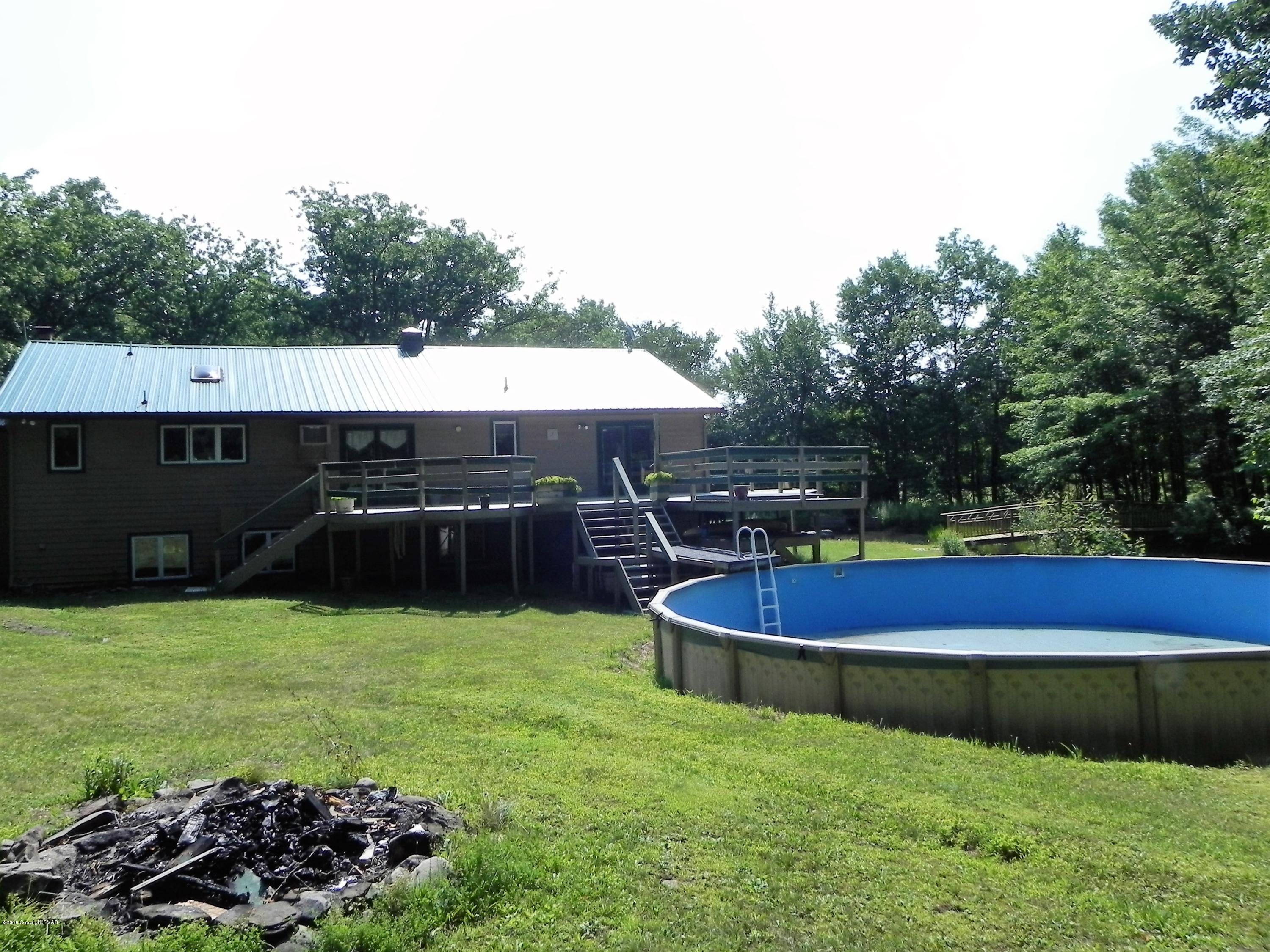 141 Rinker Road Stroudsburg, PA 18360 - Photo 28 of 29 a view of a swimming pool with lawn chairs under an umbrella