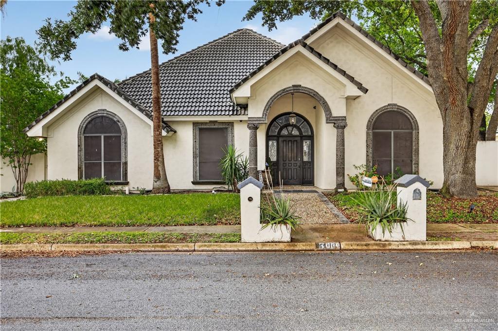 Stucco exterior with a dark tile roof and decorative stone accents