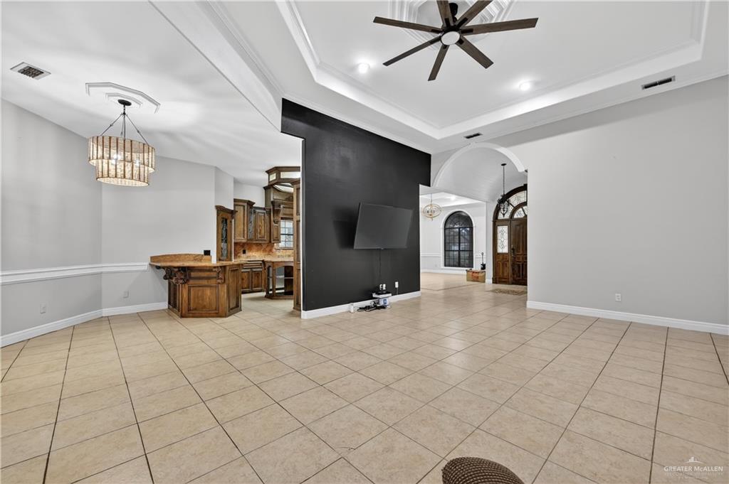 6004 North Cynthia Street McAllen, TX 78504 - Photo 11 of 25 Spacious interior featuring neutral tile flooring, tray ceiling, and a modern ceiling fan