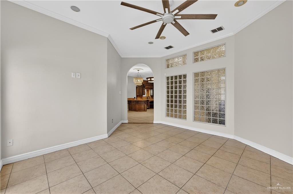 6004 North Cynthia Street McAllen, TX 78504 - Photo 15 of 25 Neutral-toned tile flooring, an arched entryway, and a ceiling fan with integrated lighting