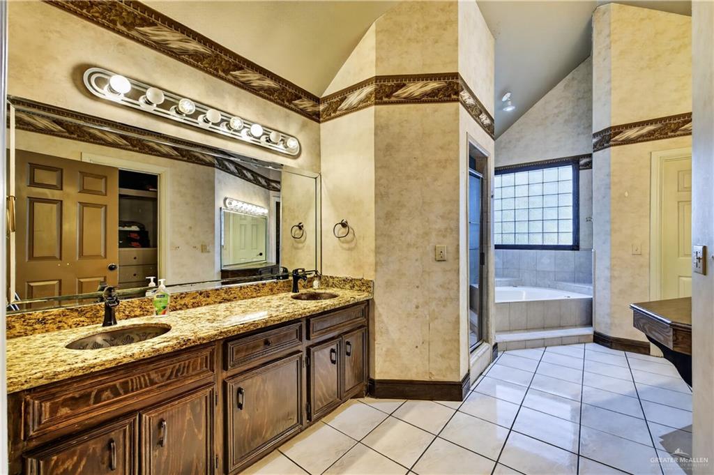6004 North Cynthia Street McAllen, TX 78504 - Photo 20 of 25 Double vanity with granite countertops, undermount sinks, and dark wood cabinetry