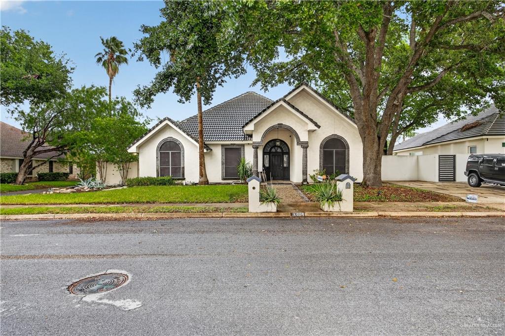 6004 North Cynthia Street McAllen, TX 78504 - Photo 2 of 25 Stucco exterior with a dark tile roof and arched window detailing