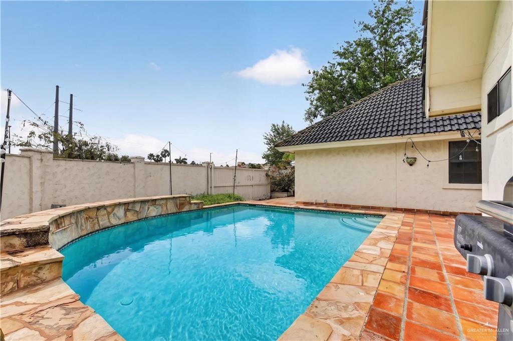 6004 North Cynthia Street McAllen, TX 78504 - Photo 25 of 25 In-ground swimming pool featuring a curved stone waterfall and integrated steps