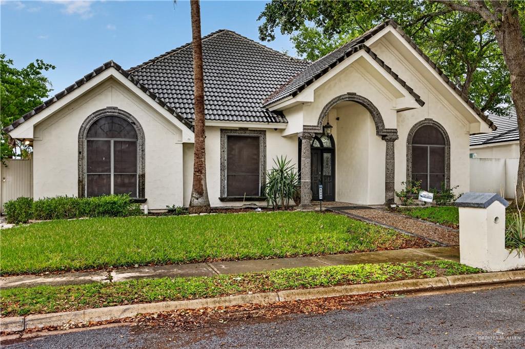 6004 North Cynthia Street McAllen, TX 78504 - Photo 3 of 25 Stucco exterior with a tiled roof and arched entryway