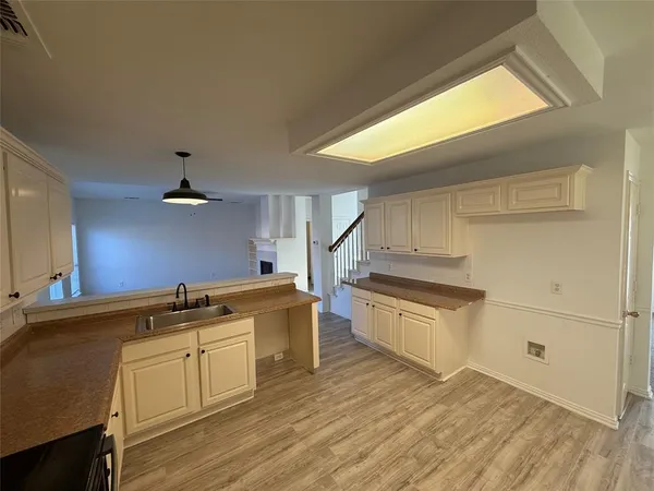 a kitchen with stainless steel appliances granite countertop a sink cabinets and wooden floor
