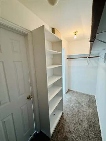 a view of walk in closet with empty racks