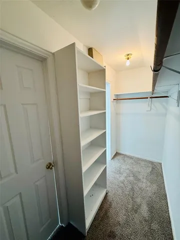 a view of walk in closet with empty racks