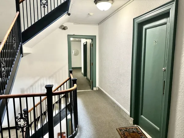 a view of a hallway with wooden floor and stairs