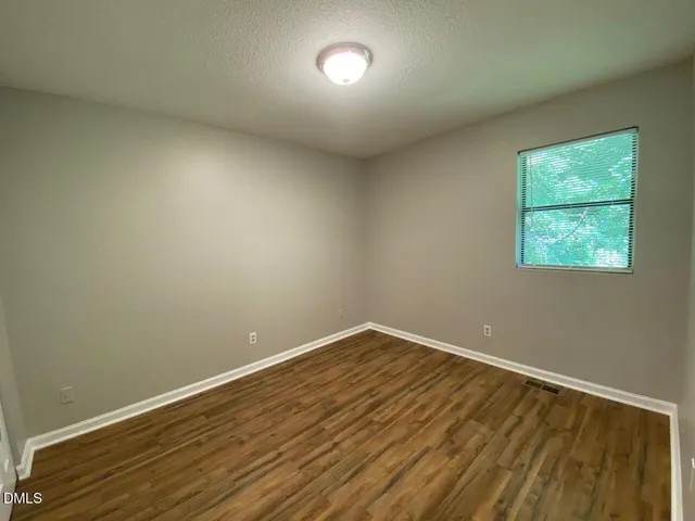 a view of room with wooden floor and fan