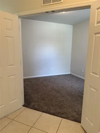 an empty room with windows and ceiling fan