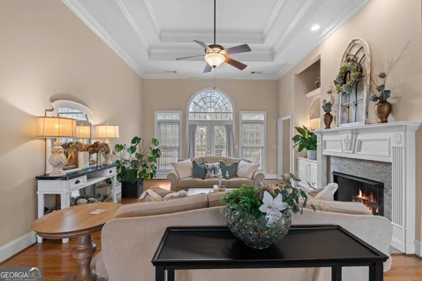 a living room with furniture a fireplace and a dining table with wooden floor