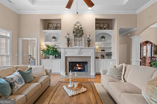 a living room with furniture a flat screen tv and a fireplace