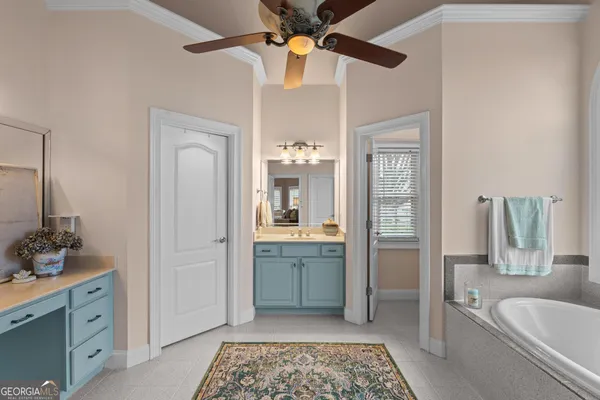 a spacious bedroom with a bed a large window with table and chairs