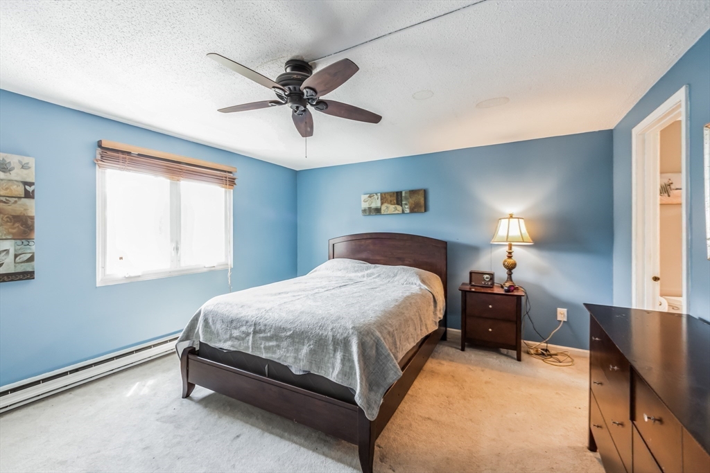 59 Seabury, Unit 59 Hampton, NH 03842 - Photo 15 of 25 a bedroom with a bed and a chandelier