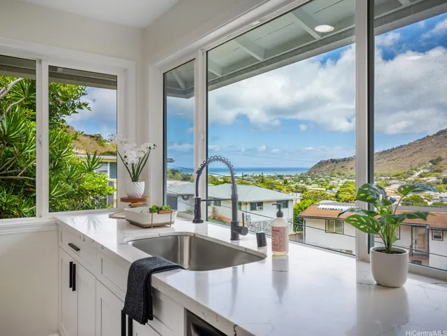 a kitchen with a large window and a potted plant