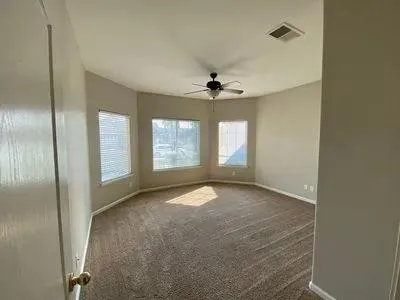 a view of a livingroom with a ceiling fan and window