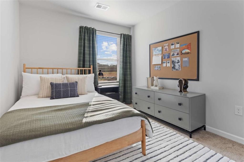 123 Meadowview Drive, Unit 15 Temple, GA 30179 - Photo 18 of 24 a spacious bedroom with a bed and a large window