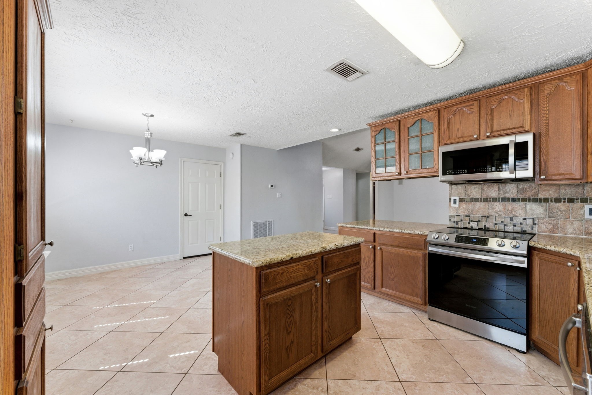 21514 Slippery Creek Lane Spring, TX 77388 - Photo 11 of 27 a kitchen with stainless steel appliances granite countertop a stove a sink and a microwave