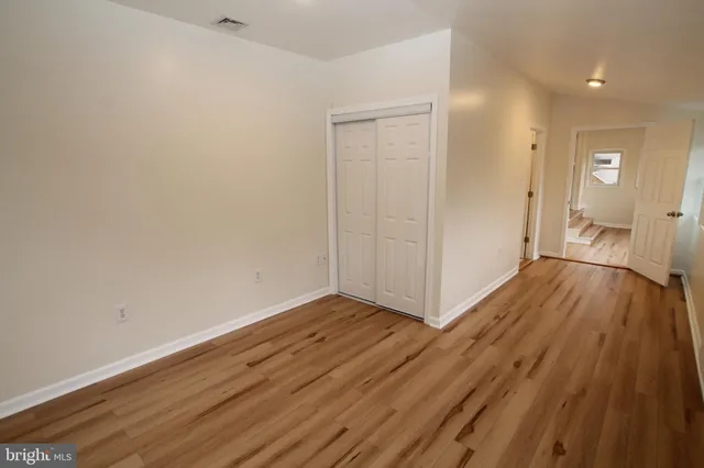 a view of a room with wooden floor and bathroom