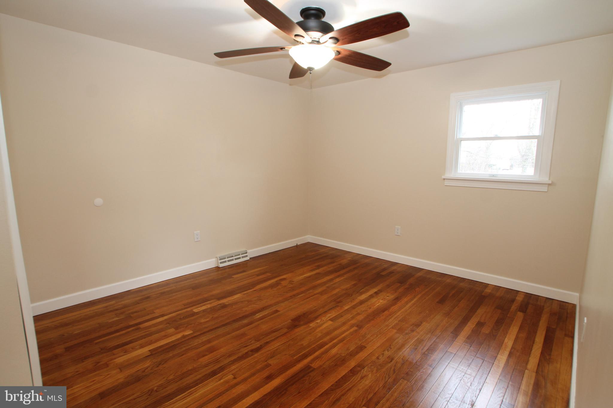 5871 Stump Road Pipersville, PA 18947 - Photo 17 of 33 an empty room with wooden floor fan and windows